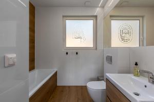 a bathroom with a white toilet and a sink at Nadmorski Spokój, domki i sauna in Lubiatowo +11 photos