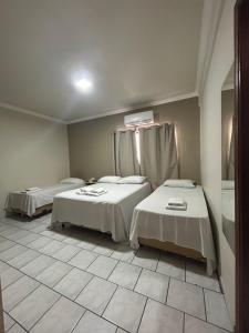 Postel nebo postele na pokoji v ubytování Hotel Parati Arapongas
