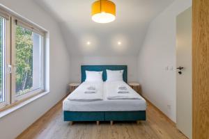 a bedroom with a bed and a large window at Nadmorski Spokój, domki i sauna in Lubiatowo