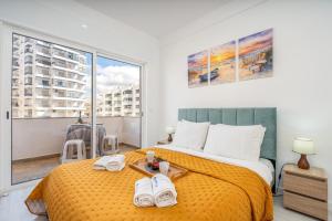 a bedroom with a large bed with towels on it at HostWise – Seaside Escape with Balcony in Silves