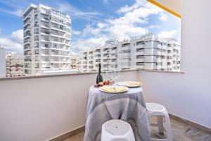 a table and chairs on a balcony with buildings at HostWise – Seaside Escape with Balcony in Silves
