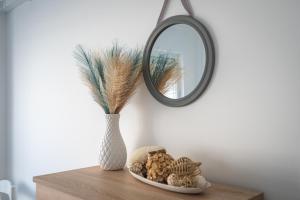 a vase sitting on a table with a mirror at HostWise – Seaside Escape with Balcony in Silves +17 photos