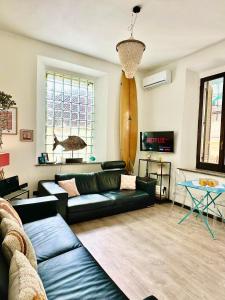 een woonkamer met een bank en een surfplank aan de muur bij surf house in Lido di Ostia