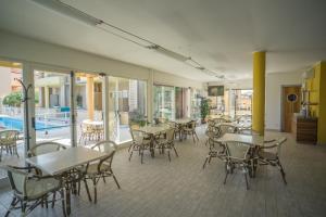 a restaurant with tables and chairs and a pool at Hotel Residence Il Conero 2 in Numana