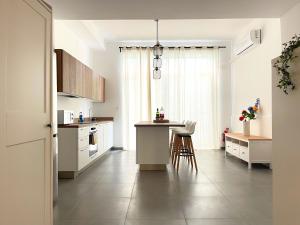 a kitchen with white cabinets and a table and chairs at Central Sliema Stay in Sliema +17 photos