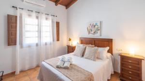 a bedroom with a bed with two shoes on it at Casa Berrocal Álora by Ruralidays in Alora +26 photos