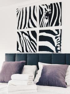 a bedroom with two zebra prints on the wall at Soft Loft Apartamenty in Toruń
