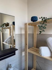 a bathroom with wooden shelves and a mirror at Casa Vacanze Matilde Marzamemi in Marzamemi