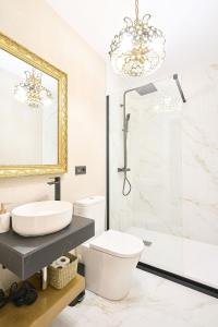 Un baño con inodoro, lavabo y espejo. en Apartamentos propia Plaza Mayor collection Luxury, en Salamanca 29 fotos más
