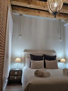 Un dormitorio con una cama grande con dos toallas encima. en Apartamentos propia Plaza Mayor collection Luxury, en Salamanca