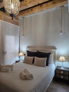 Un dormitorio con una gran cama blanca con dos almohadas. en Apartamentos propia Plaza Mayor collection Luxury, en Salamanca