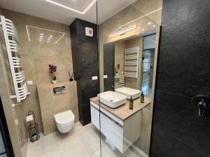 a bathroom with a sink and a toilet and a shower at Nowy Apartament Mikołowska Premium in Gliwice +24 photos