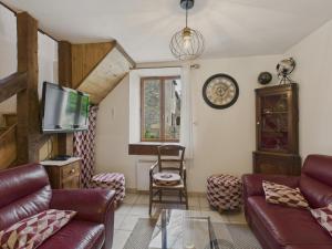 un salon avec un canapé et une télévision dans l'établissement Charmante maison en pierre pour 6 - Valojoulx, à Castang
