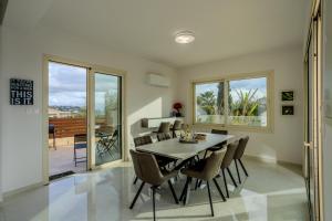a dining room with a table and chairs at H&O Miki's Seaview House in Kissonerga