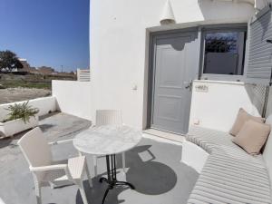 a patio with a table and chairs and a door at Evnia apartments in Vóthon