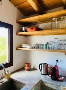 a kitchen with wooden shelves and a counter top at Quinta da Vida in Moncarapacho