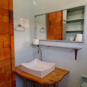 a bathroom with a sink and a mirror at Pousada e Hospedaria Alternativa Ladi Laura in Urubici