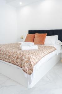 a white bed with orange and white pillows on it at Torre Solana 41 in Cádiz