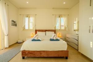 a bedroom with a large bed with towels on it at H&O Miki's Seaview House in Kissonerga