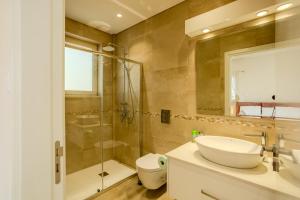 a bathroom with a sink and a shower and a toilet at H&O Miki's Seaview House in Kissonerga