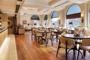 a restaurant with tables and chairs and windows at Hilton York in York +84 photos
