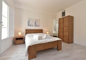 a bedroom with a large bed with white sheets and towels at Sud Casa Vacanze in Ragusa