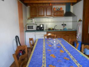 una cocina con mesa y mantel azul. en Gite du plô en La Cresse