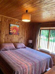 Un dormitorio con una cama con techo de madera. en Cabañas Antualen Casa 2, en Pucón