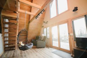a person sitting in a hammock in a living room at River End A-Frame in Emily