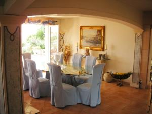 a dining room with a table and white chairs at Villa Ginevra in Menton