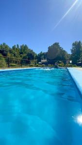 una gran piscina con agua azul en Cabañas Antualen Casa 2, en Pucón