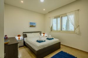 a bedroom with a bed and a desk and a window at H&O Miki's Seaview House in Kissonerga