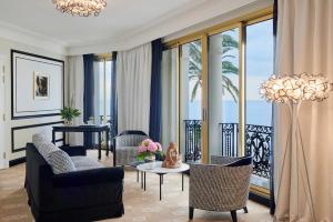 a living room with chairs and a room with a balcony at Hotel Le Negresco in Nice