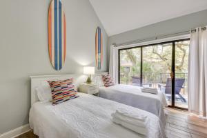 two beds in a white room with a window at Tennis, Golf and More Seabrook Island Getaway! in Seabrook Island