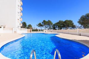 a swimming pool with blue water in front of a building at Rentalmar Los Angeles in Miami Platja