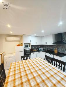 a kitchen with a table with a plaid table cloth at Casa dos meus avós Mar & Biscoitos in Biscoitos