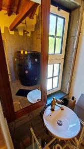 a bathroom with a sink and a mirror at Casa dos meus avós Mar & Biscoitos in Biscoitos +33 photos