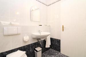 a white bathroom with a sink and a toilet at Ostseeresidenz Appartements Wischuer Fewo 26 in Wischuer