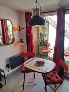 a dining room with a table and chairs and a window at Le Petit Parisien- Bienvenue - Netflix - Terrasse - Parking - Porte de Paris - Climatisation - Guide visite à Paris OFFERT in Pantin
