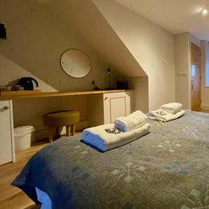 Un dormitorio con una cama con dos toallas encima. en Nant y Ffynnon 1, en Llithfaen