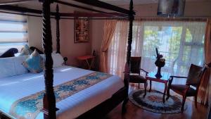 una camera con letto a baldacchino e finestra di Bibby's B&B a East London Altre 16 foto