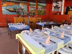 a dining room with blue tables and white chairs at Hôtel Kiriboungni chez sylfatou in Tahire +52 photos