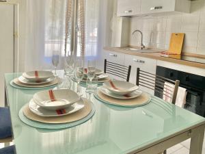 a kitchen with a table with plates and wine glasses at Ca del Mare - FREE Parking in La Spezia