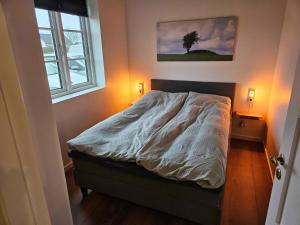 a bed in a bedroom with a tree in the corner at Beautiful Holiday Home In Rural Surroundings in Hadsund
