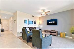 a living room with a couch and a tv on a wall at Beautiful Condo Only 6 Minutes From Disney World in Kissimmee