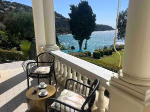 two chairs and a table on a porch with a view of the water at Diodato Luxury Residence Corbusier Promenade & Sea View with Pool #3 in Roquebrune-Cap-Martin