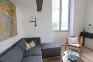 a living room with a gray couch and a chair at Diodato Luxury Residence Corbusier Promenade & Sea View with Pool #3 in Roquebrune-Cap-Martin