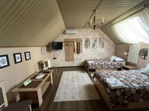 a room with a bed and a couch and a table at Готель GUEST HOUSE Сауна in Radekhov