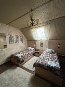 a bedroom with two beds and a ceiling at Готель GUEST HOUSE Сауна in Radekhov