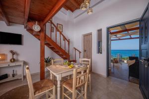 a dining room with a table and chairs with a view of the ocean at GM Appartment in Lentas by South Cretan Villas in Lentas